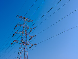 青空に伸びる送電線と鉄塔　電力インフラのイメージ