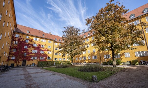 Inner courtyard with yellow apartment buildings, Borstei, heritage-protected residential estate, in autumn, Moosach district, Munich, Bavaria, Germany