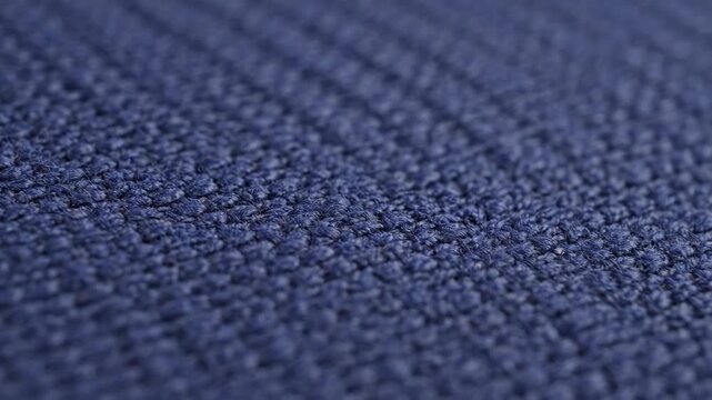 Abstract dark blue woven fabric texture with detailed pattern and shallow depth of field