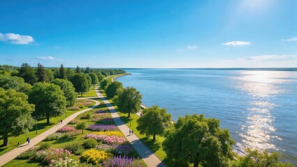 Fototapeta premium Sunny Lakeside Park Promenade with Sparkling Lake and Blooming Flowers Under Clear Blue Sky