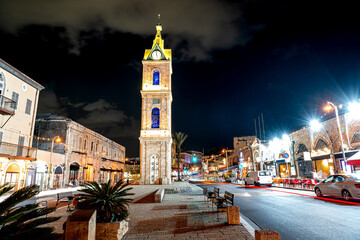 Fototapeta premium Jaffa Clock Tower, Tel Aviv night cityscape with taxis and restaurants, Israel.