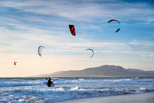Kitesurfers at sunset in Tarifa, a surfers' paradise in Spain.