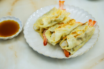 접시 위 새우 만두와 간장 