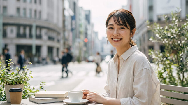 Authentic Asian woman smiles while enjoying coffee at outdoor cafe in city street