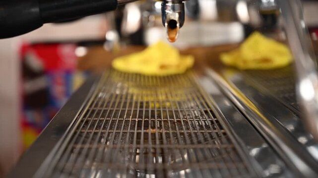 Close up video of a professional coffee machine while a barista prepares espresso by tamping ground coffee into the portafilter, locking the handle, placing the cup, and extracting a rich espresso 