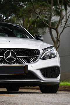 Silver Mercedes-AMG C43 front corner close up, Luxury sedan headlight and grill details