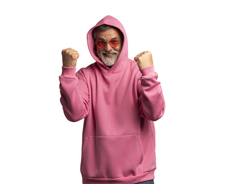 Handsome mature man with beard wearing casual pink sweatshirt over transparent background. Very happy and excited, doing winner gesture with arms raised, smiling and screaming for success