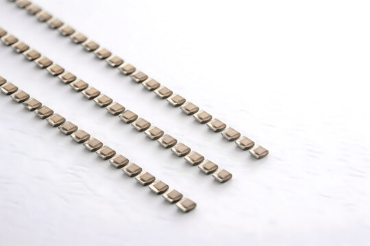 Surface Mount Electronic Components on Carrier Tape Strips Isolated on White Background with Copy Space
