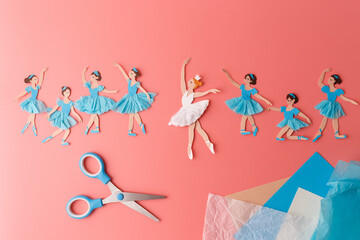 Paper cut ballerinas dancing on pink background scissors tissue paper craft supplies creative diy art project for kids primary school education hobby handmade ballet dancers figures flat lay.