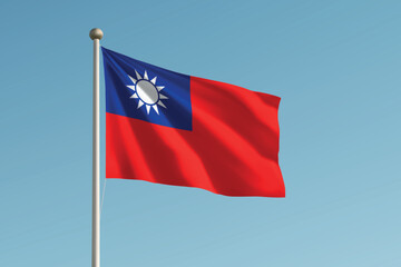 Naklejka premium Taiwan national flag waving on pole against clear blue sky background.