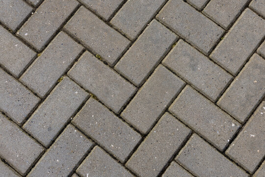 Grey herringbone interlocking paving brick background texture