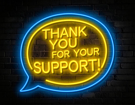 Leuchtende gelbe Neonschrift "Thank you for your Support!" auf dunkler Backsteinmauer