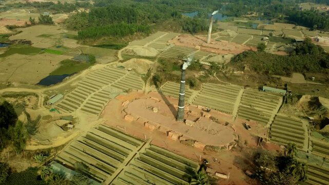 Aerial Drone View of Brick Kiln Factory with Smoking Chimneys Causing Air Pollution in Rural Bangladesh Landscape 4k