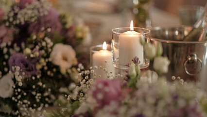 Elegant candlelit dinner table setting with romantic floral arrangements and a champagne bucket in soft lighting