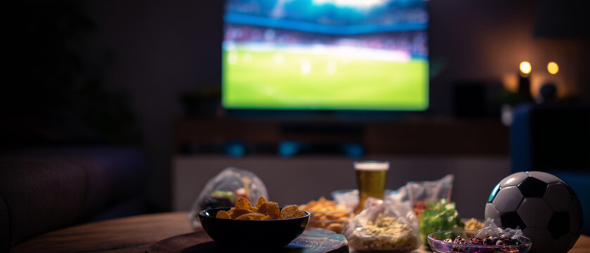 Ambiente de bar com jogo de futebol na TV simboliza torcida coletiva, entretenimento esportivo, confraterniza&ccedil;&atilde;o e lazer fora de casa