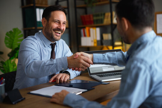 Business partners sealing deal with handshake in office