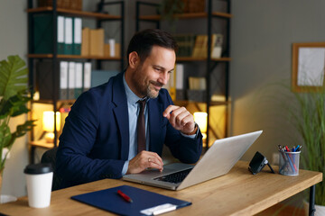 Fototapeta premium Businessman thinking while working on laptop in home office