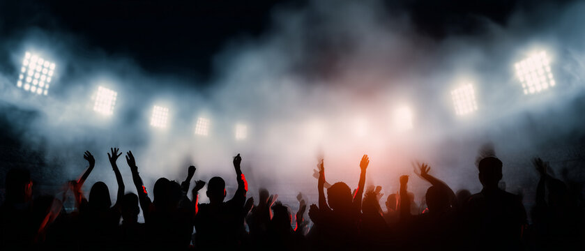Silhuetas de torcedores comemorando em arena esportiva iluminada, representando emo&ccedil;&atilde;o, futebol e energia vibrante em est&aacute;dio lotado