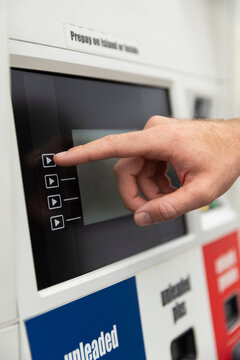 Man pumping gas at station car