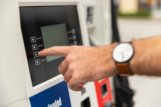 Man pumping gas at station car