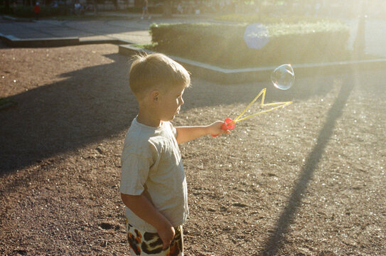 Child blowing bubbles in a sunny park 