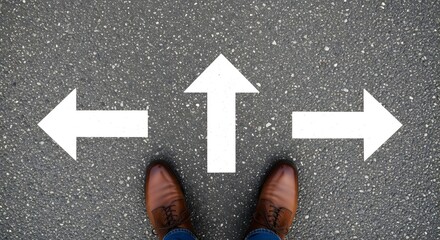Fototapeta premium Person standing on asphalt road with white arrows pointing in different directions indicating choices