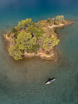 Inflatable kayak in crystalline waters rowing towards an island. 