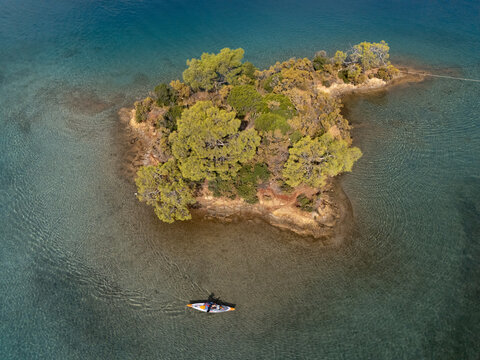 Kayaker rowing around a pretty island 