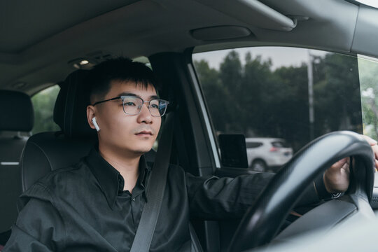 An Asian man sitting in the car