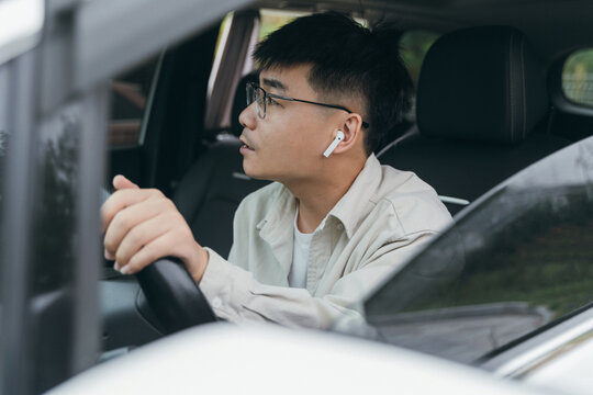 An Asian man sitting in the car