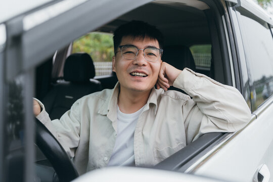 An Asian man sitting in the car
