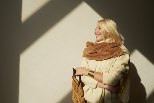 Woman poses joyfully with a warm scarf