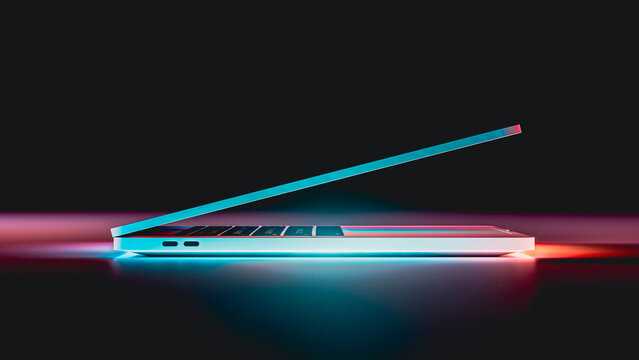 Laptop glows with vibrant neon lights in a dark setting