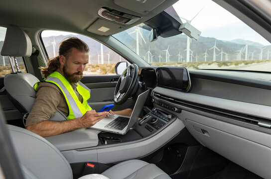 Wind Turbine worker texts on cell phone 