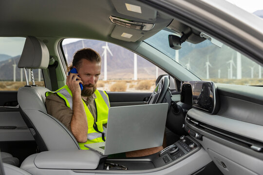 Wind Turbine Engineer  works remote laptop in car 