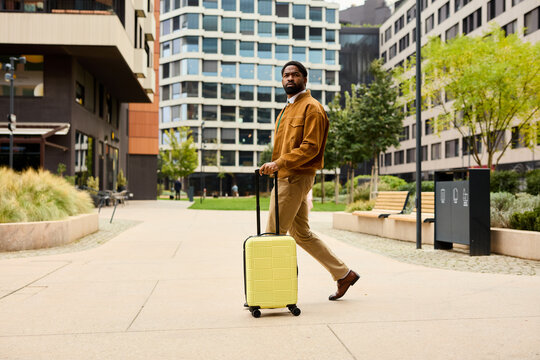 Stylish man walks with a suitcase