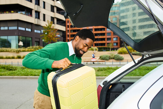 Man puts suitcase in his vehicle