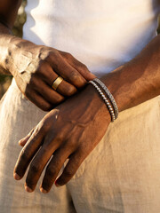 Hands showing jewelry with a focus on bracelets in natural light