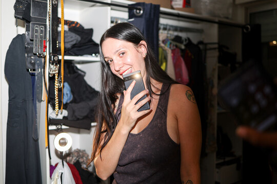 Woman Smiling While Holding a phone in a Room
