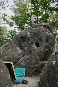 Male climber topping a boulder at Fountaineblueau 