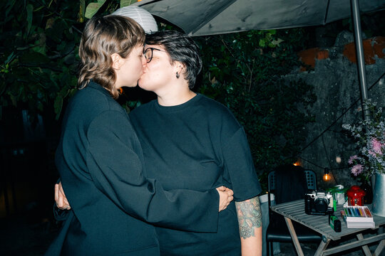 Couple Sharing a Kiss Under Flash Lighting During a Party
