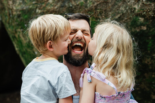 Small children loving on their dad