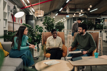 Naklejka premium Diverse business team collaborating in comfortable office lounge