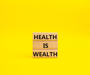 Fototapeta premium Health is Wealth symbol. Concept word Health is Wealth on wooden blocks. Beautiful yellow background. Medicine and Health is Wealth concept. Copy space