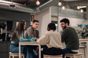 Diverse team meeting discussing ideas in office breakroom