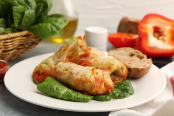 Yummy stuffed cabbage rolls served on grey table, closeup
