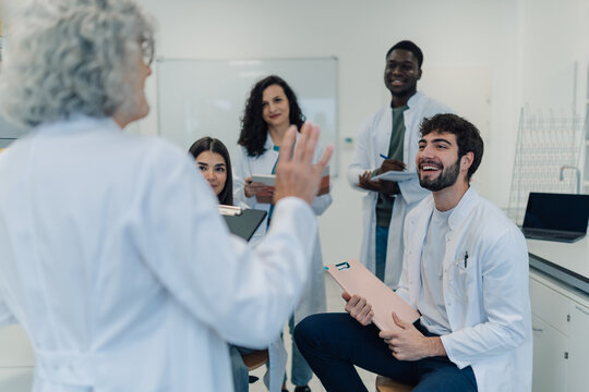Professor teaching diverse medical students in science class