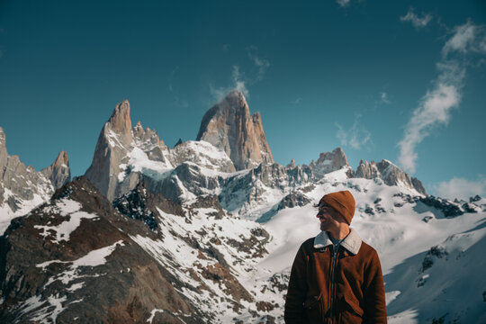 Man enjoying the view of snow-capped Mount Fitz Roy on a sunny day