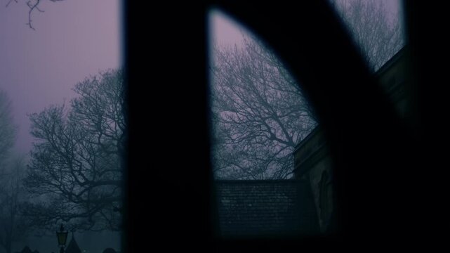 Lonely Graveyard on foggy day though view of lych gate