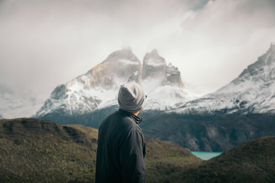 Man contemplating majestic snow-capped mountains in Patagonia